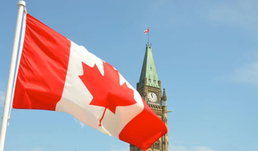 Canadian flag flying in front of the Peace Tower on Parliament Hill in Ottawa